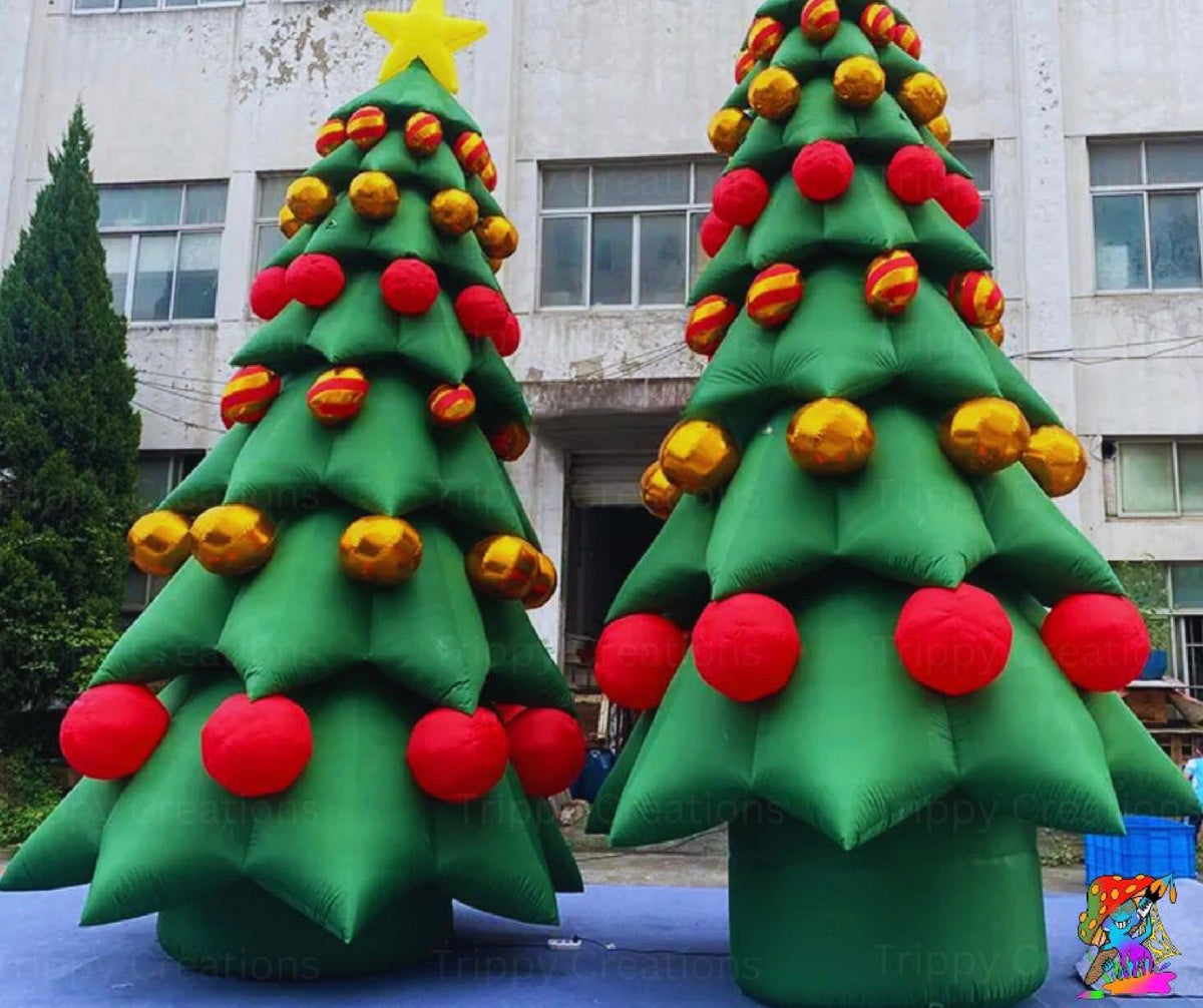 Two giant inflatable Christmas trees with red and gold baubles displayed outdoors