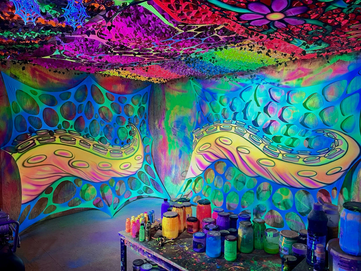 Colourful studio with two painted tentacle webs and jars of paint