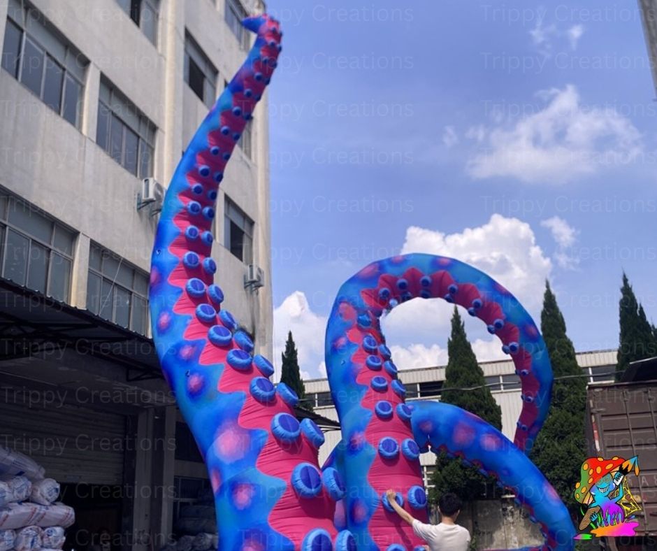 Large inflatable octopus sculpture with blue and pink tentacles in an urban setting.