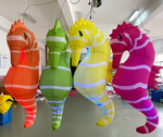Four colorful inflatable seahorses hanging indoors.