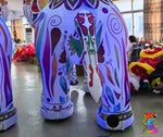 Colorful inflatable elephant with intricate designs in a room setting.