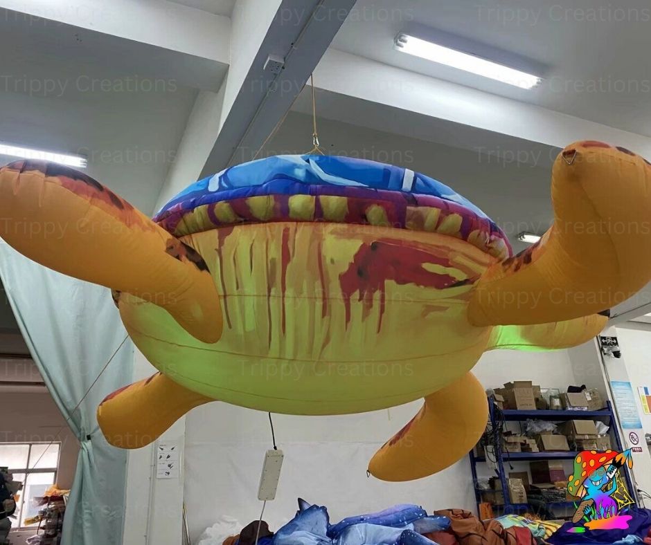 Inflatable sea turtle decoration hanging in a room with visible ceiling lights and walls.