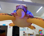 Inflatable sea turtle decoration hanging from the ceiling in a room.