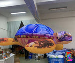 Inflatable sea turtle decoration hanging indoors with visible branding.