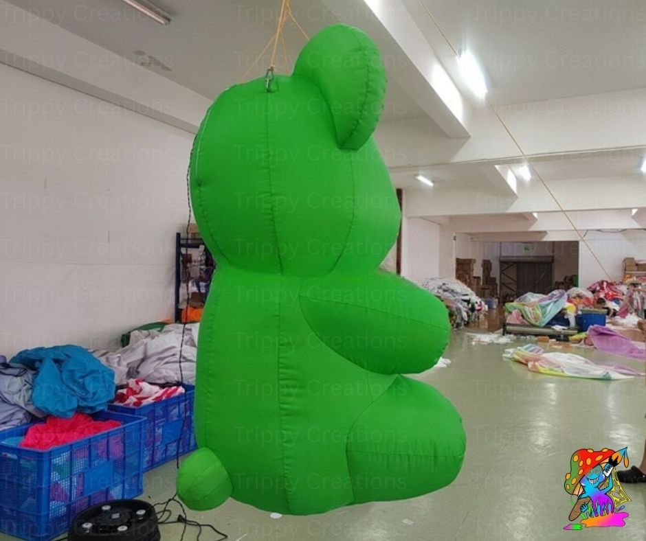Green inflatable bear hanging in a warehouse setting