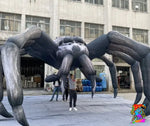Close-up of a creepy inflatable spider with stretchable legs, used for Halloween party décor.