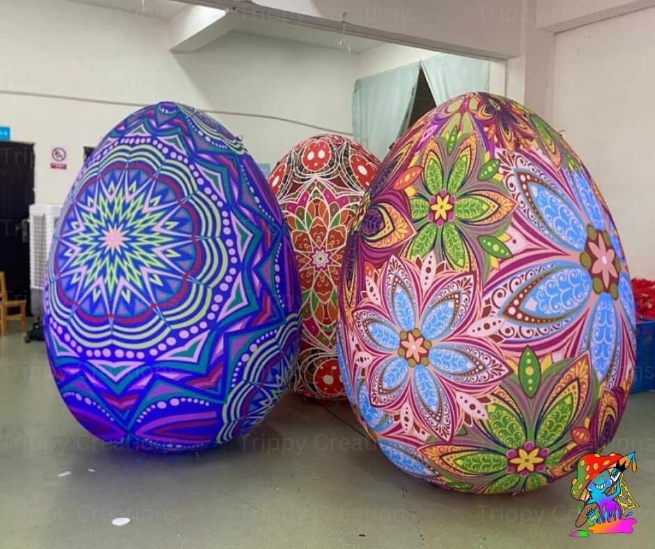Three large, colorful decorated eggs with intricate patterns on a plain surface.