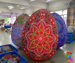 Colorful mandala-patterned balls in a room with people and tables.