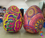 Two large, colorful Easter eggs with intricate patterns on a plain surface.