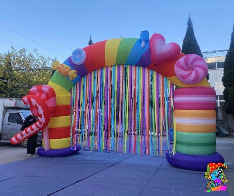 Colorful inflatable arch with candy-themed decorations on a clear day.