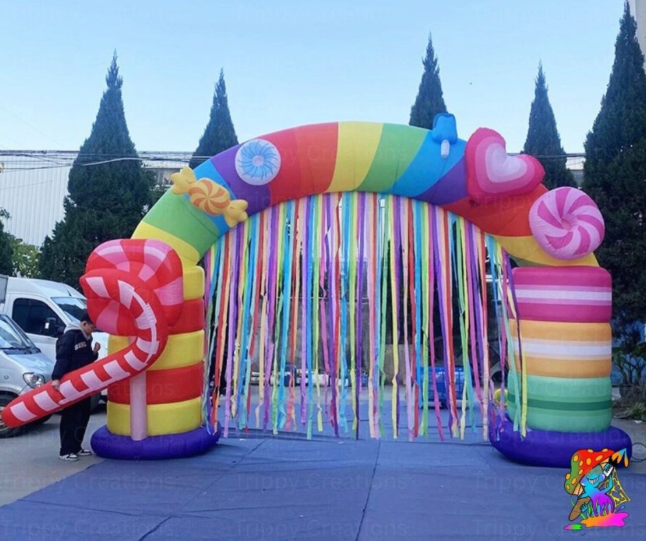 Colorful inflatable arch with candy-themed decorations on a clear day.