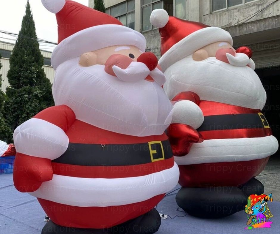 Two inflatable Santa Claus figures in front of a building.