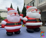 Two inflatable Santa Claus figures in front of a building.