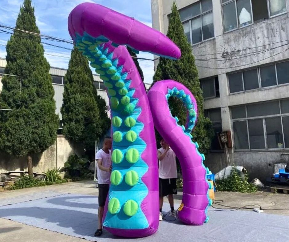 Giant inflatable tentacle decoration in purple and blue, displayed outdoors.
