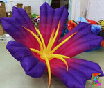 Inflatable flower with purple petals and yellow center on a plain background