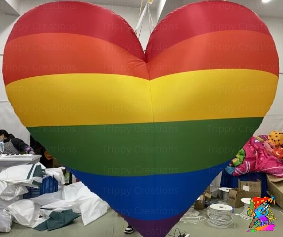 Inflatable heart-shaped balloon with rainbow colors in a workshop setting.