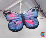 Large butterfly-shaped kite with colorful wings hanging indoors.