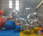 Inflatable bubble spheres in a warehouse setting with 'Trippy Creations' branding.