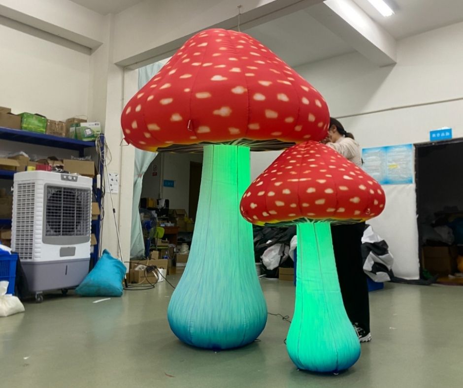 Giant inflatable mushroom decorations with LED lights, displayed indoors.