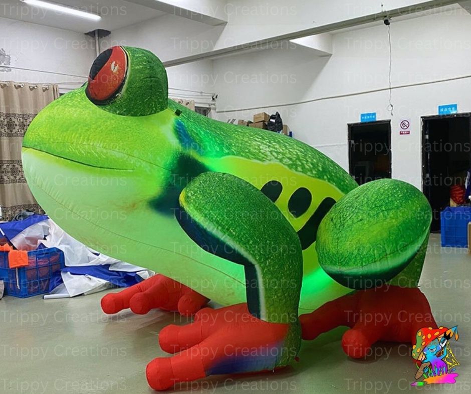 Large inflatable green frog model in a warehouse setting