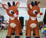 Two inflatable reindeer decorations with brown bodies, white hooves, black antlers, and red noses, displayed indoors.