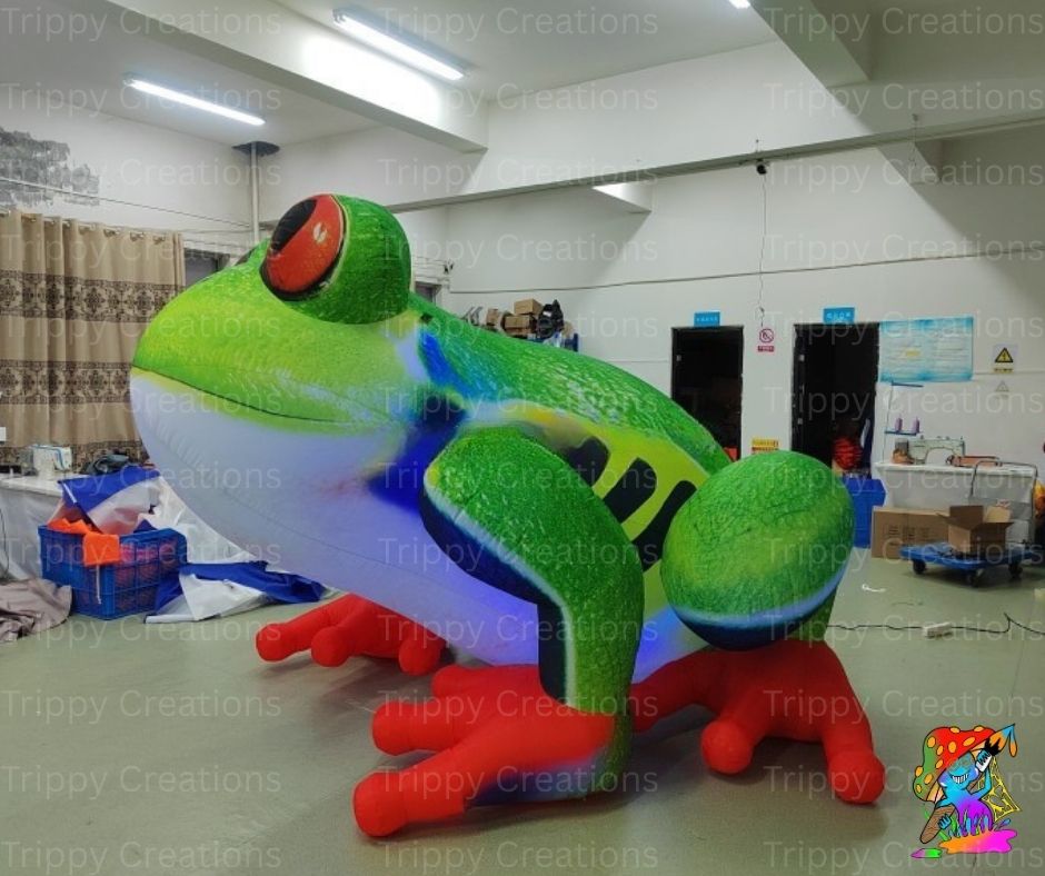 Large inflatable frog decoration in a warehouse setting with 'Trippy Creations' branding.