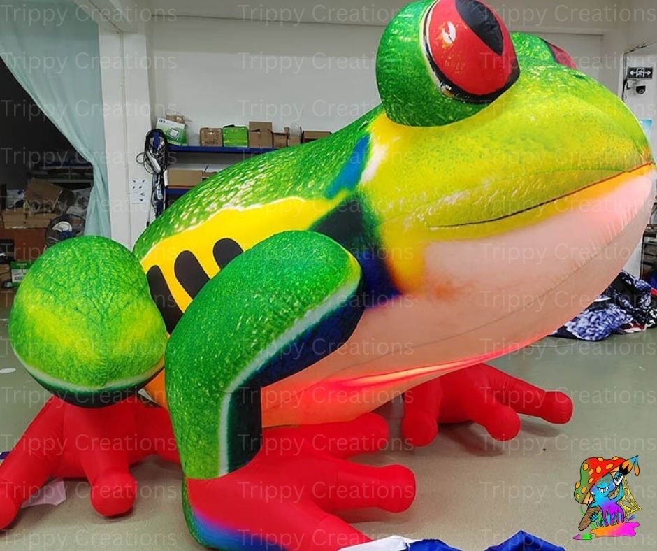 Colorful inflatable frog sculpture in a warehouse setting