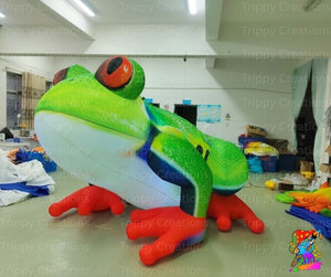 Inflatable frog decoration in a warehouse setting with 'Trippy Creations' branding.