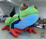 Large inflatable frog decoration with red feet and green body in a warehouse setting.