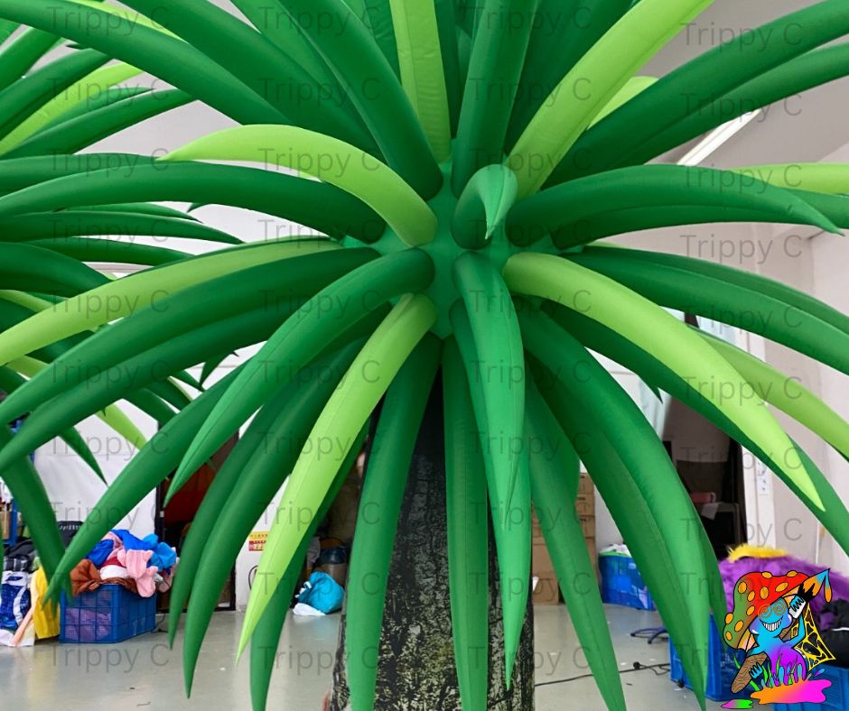 Large inflatable green plant with a tree trunk in an indoor setting.