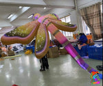 Inflatable slide with colorful design in a warehouse setting.