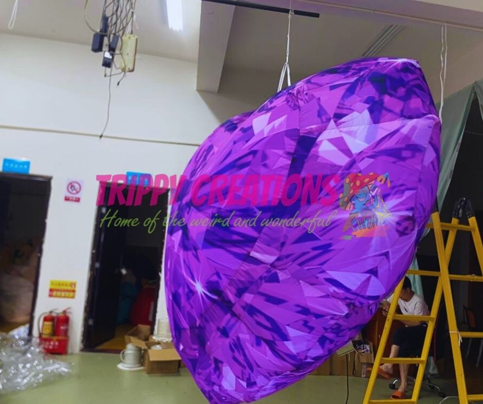 Purple inflatable diamond with 'Trippy Creations' branding in a workshop setting