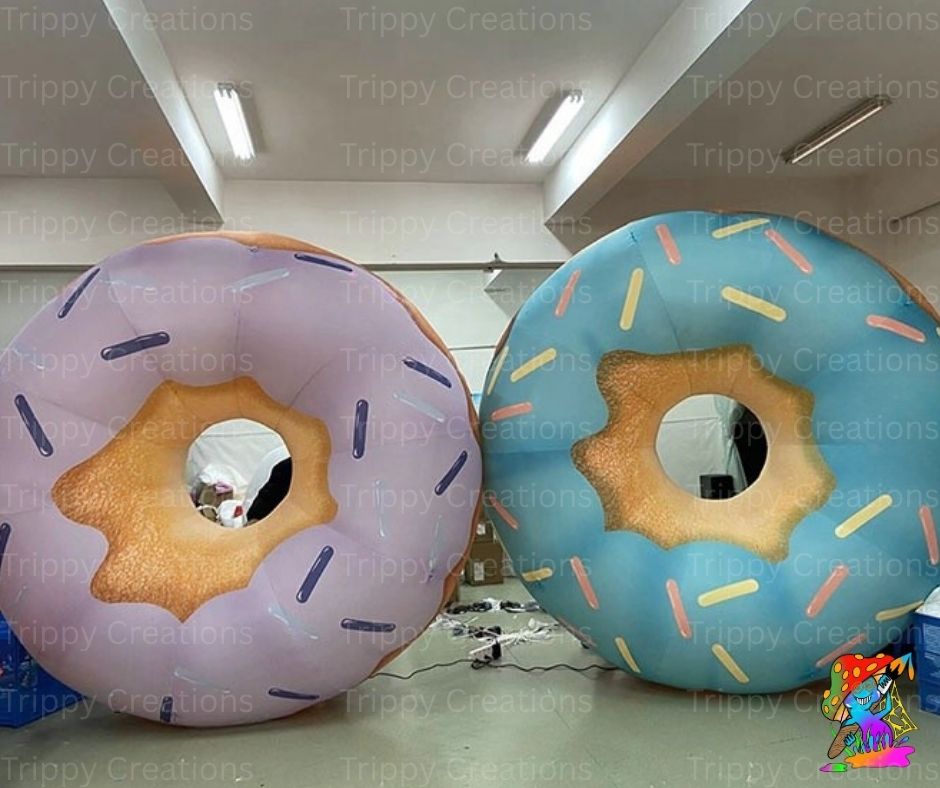 Two inflatable donut props with colorful icing in a room setting.