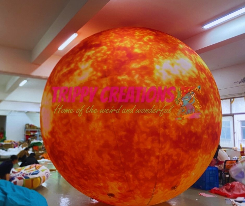 Inflatable sphere with 'Trippy Creations' branding in a room setting