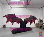 guests posing in front of inflatable bat wings creating social media photo moment