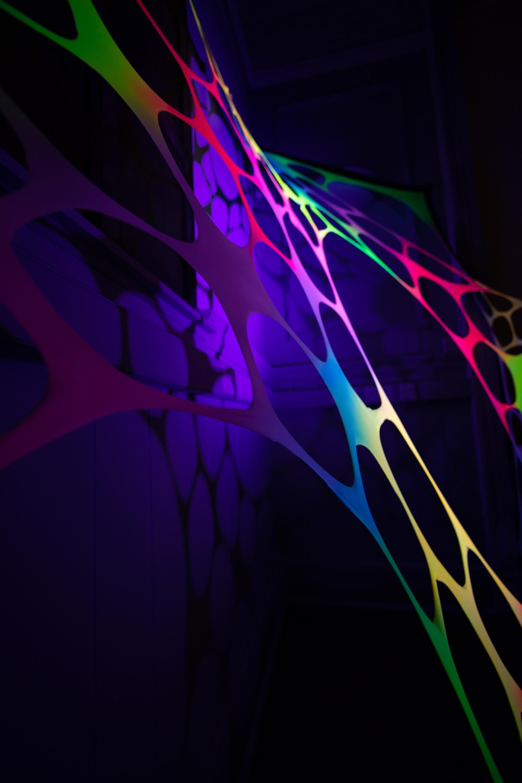 Glow-in-the-dark psychedelic rainbow wall hanging for hire