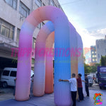 Large LED rainbow inflatable arch transforming an indoor exhibition entrance with vibrant commercial lighting.