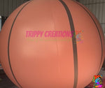 Giant inflatable basketball hanging from ceiling for sports themed party decor