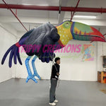 Performer wearing a 3.5m giant tropical parrot walking parade costume at a carnival event