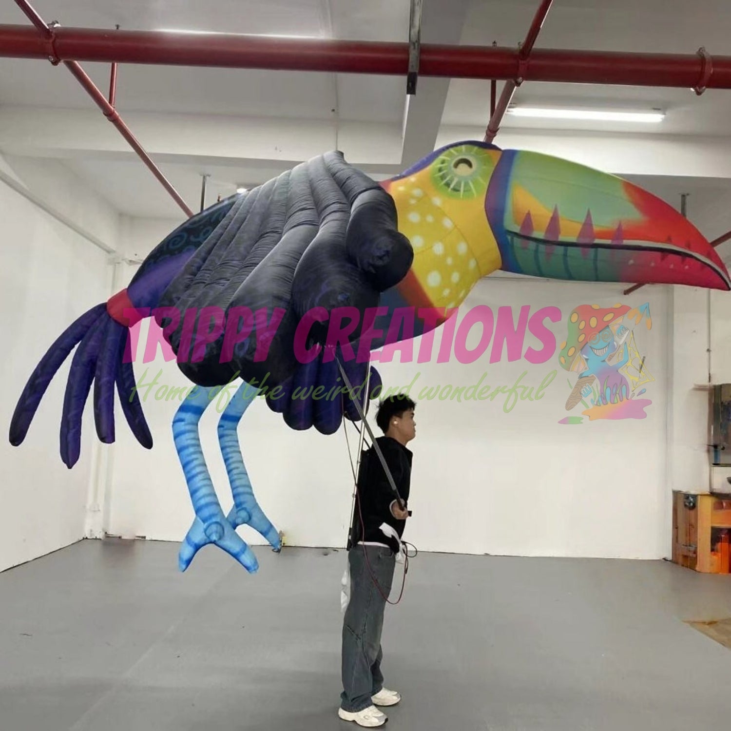 Performer wearing a 3.5m giant tropical parrot walking parade costume at a carnival event