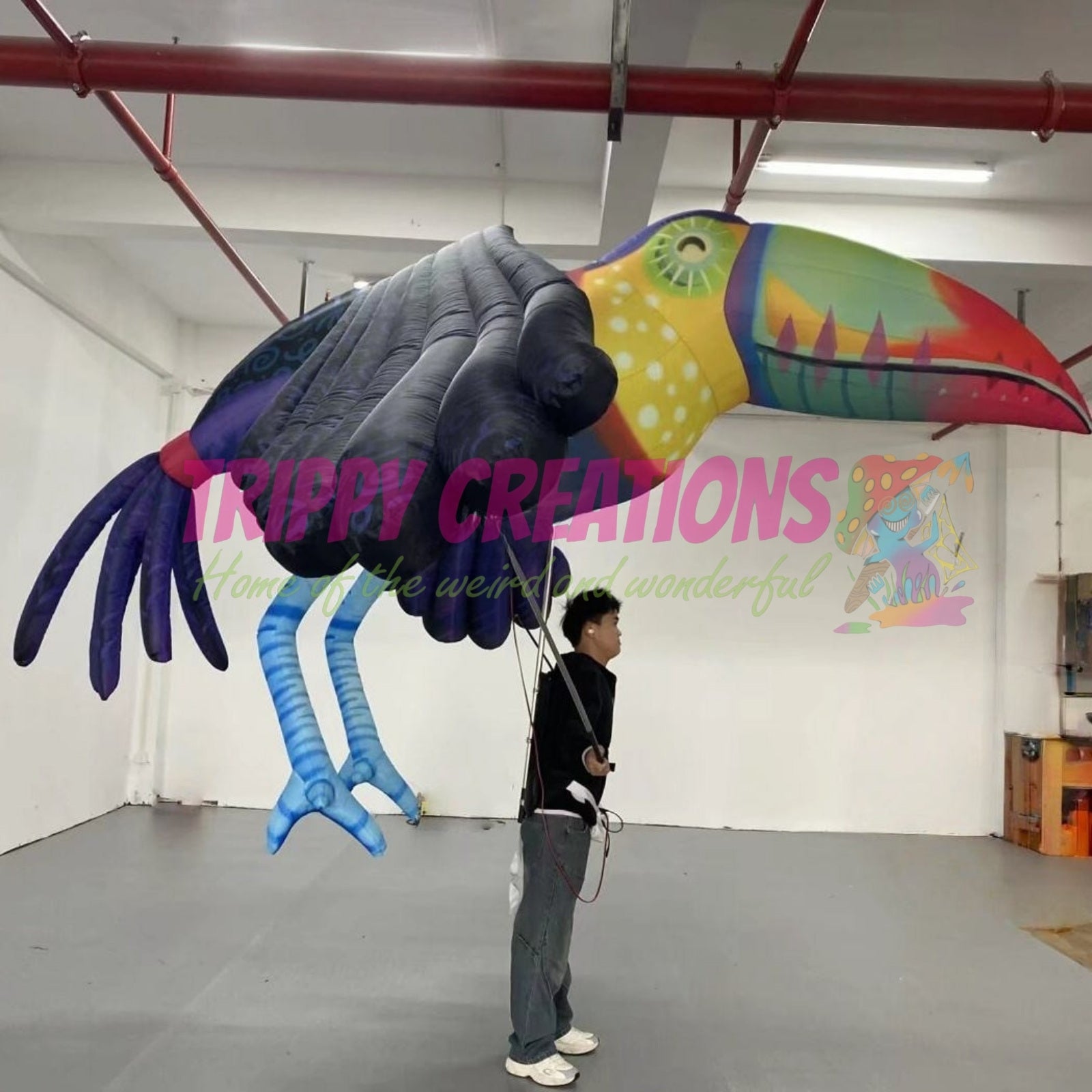Performer wearing a 3.5m giant tropical parrot walking parade costume at a carnival event