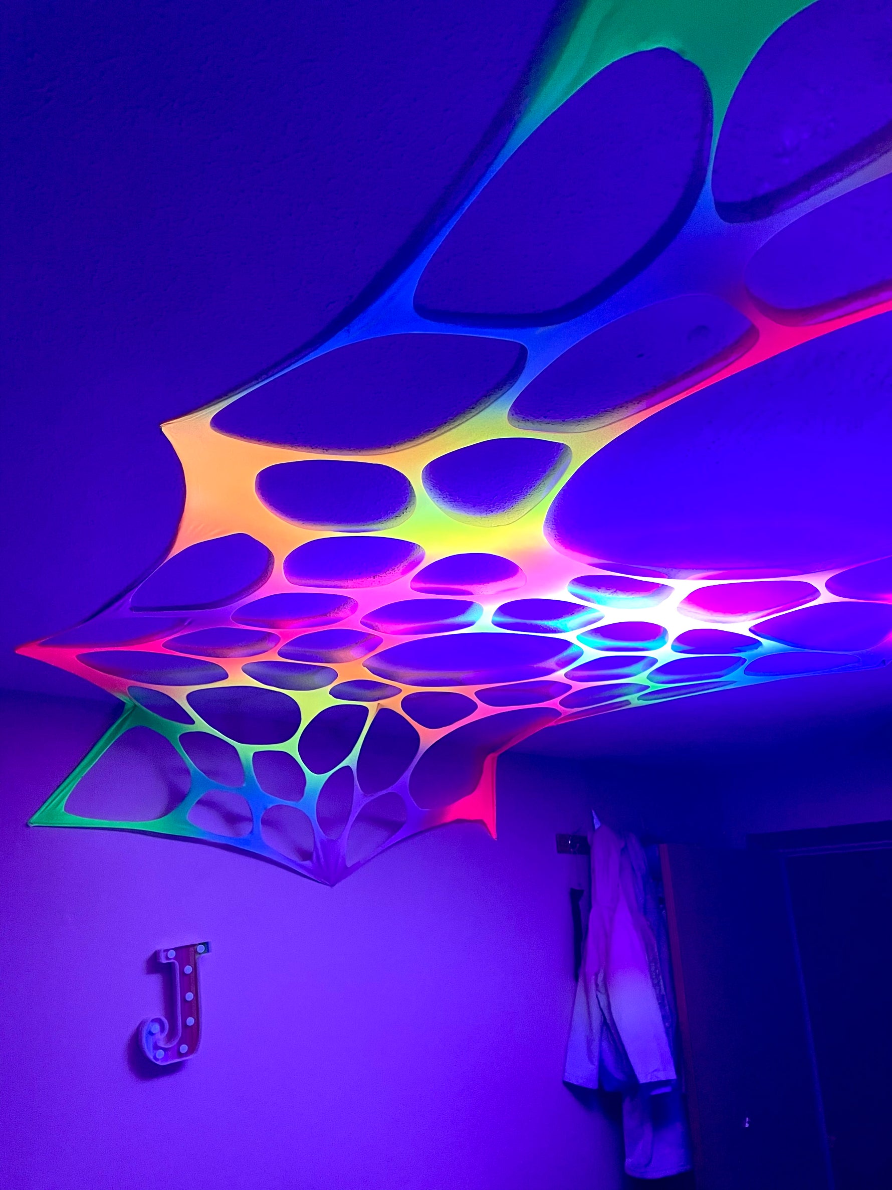 Vibrant UV-reactive rainbow wall decorations for hire