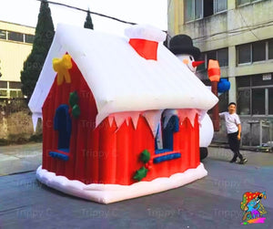 Inflatable snowman-shaped playhouse with a person standing nearby in an urban setting.