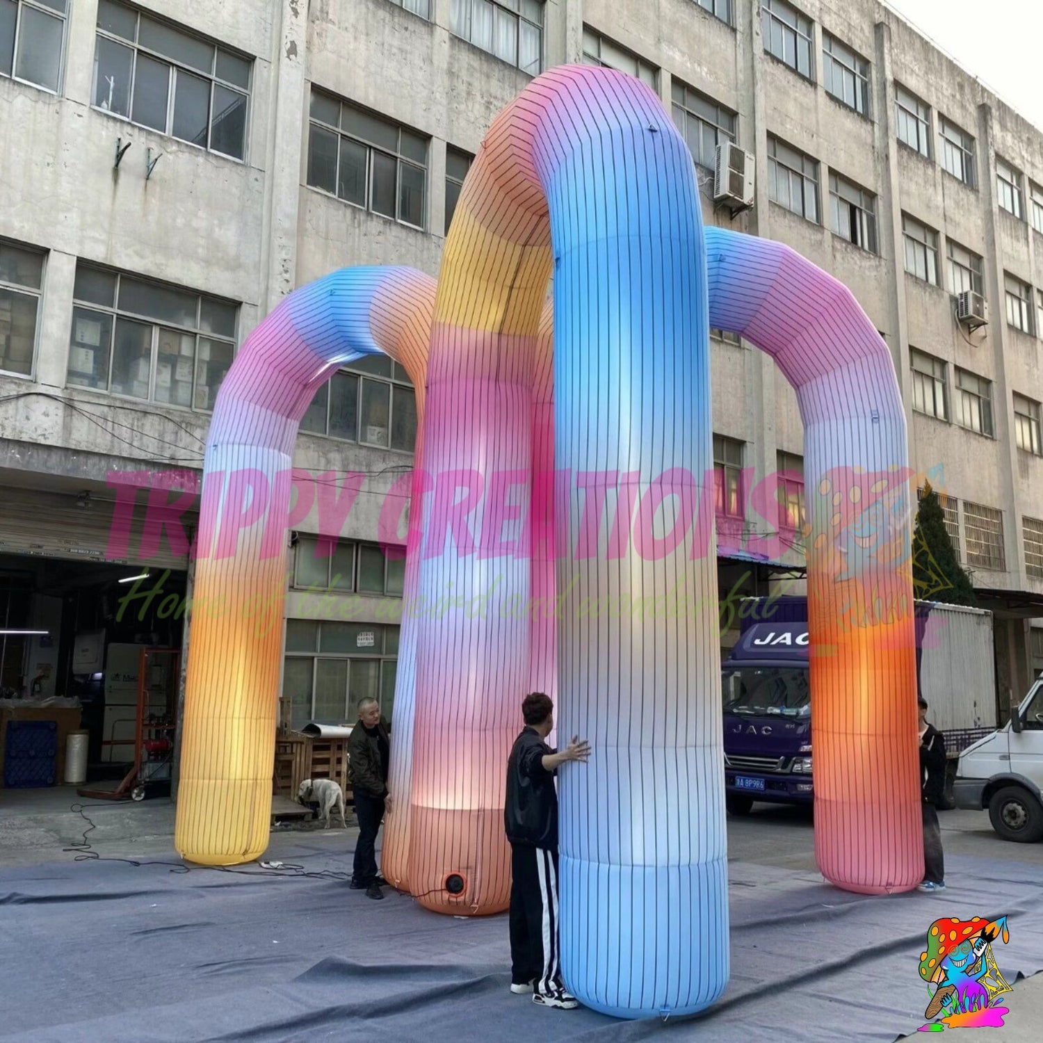 Large rainbow illuminated inflatable entrance arch installed at an outdoor festival to create a memorable guest arrival experience.