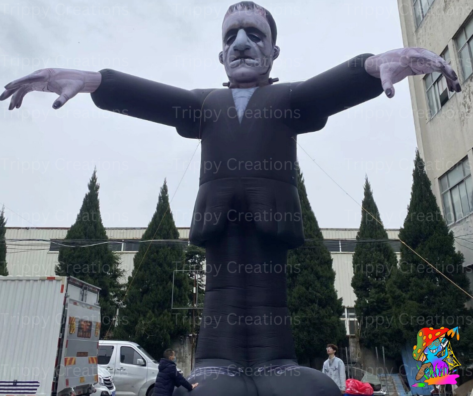 Inflatable figure of a person in a suit with arms outstretched, outdoors with trees and buildings in the background.
