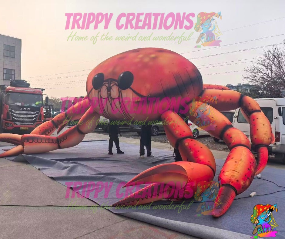 Inflatable crab decoration with 'Trippy Creations' branding on a street.