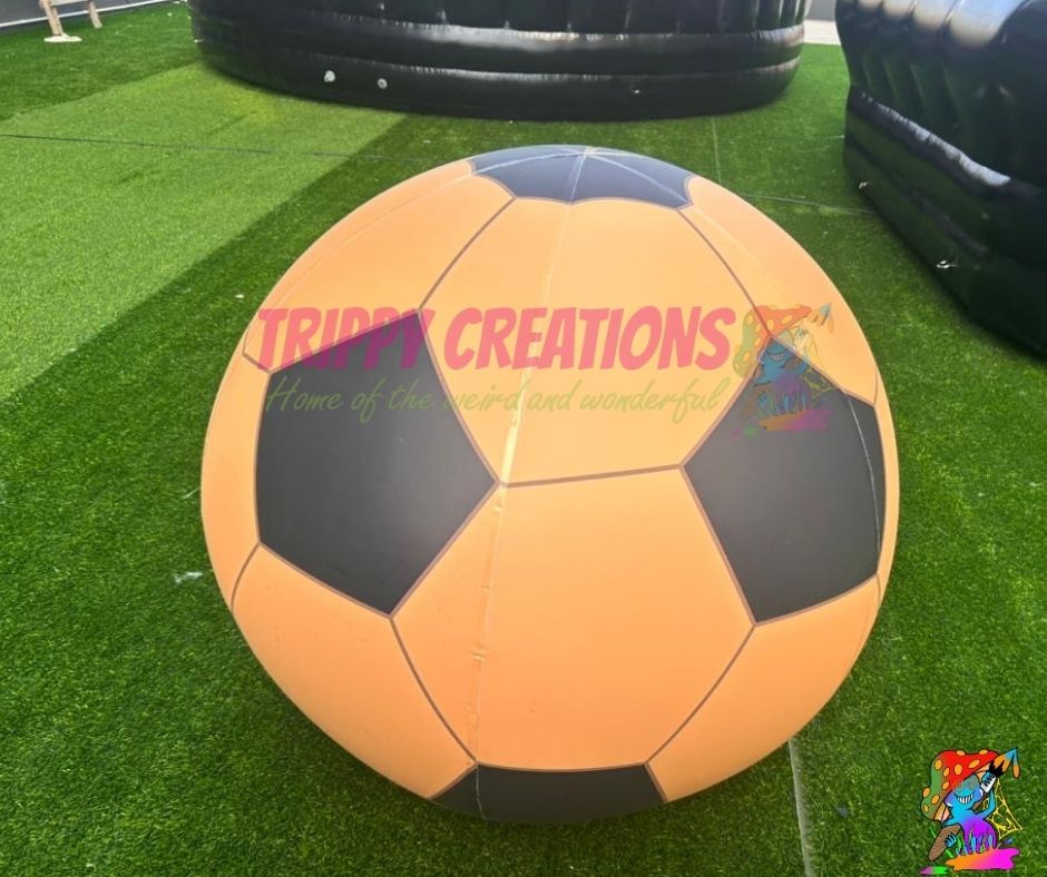 Large inflatable soccer ball on artificial grass with 'Trippy Creations' branding.