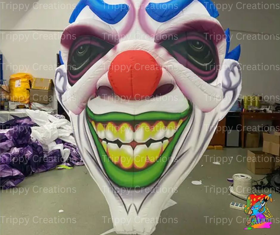 Inflatable scary clown face decoration with exaggerated features, hanging from ceiling at a haunted circus-themed party.