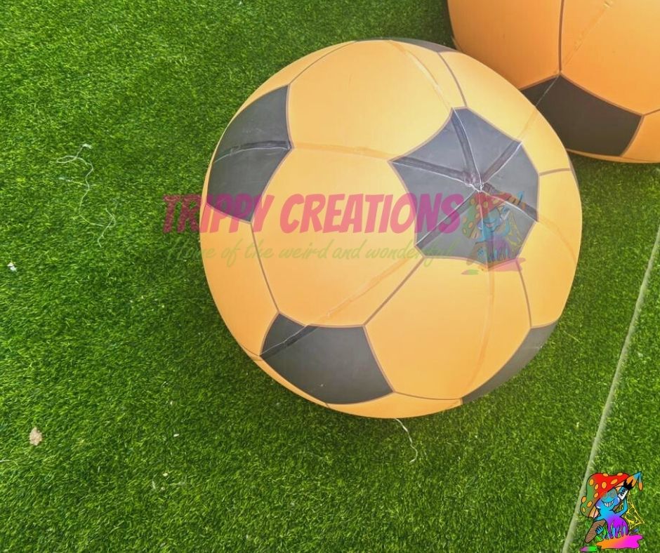Yellow and black soccer ball on green grass with 'tippy Creations' branding.