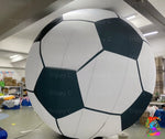 Large inflatable soccer ball in a warehouse setting with 'Trippy C' branding.